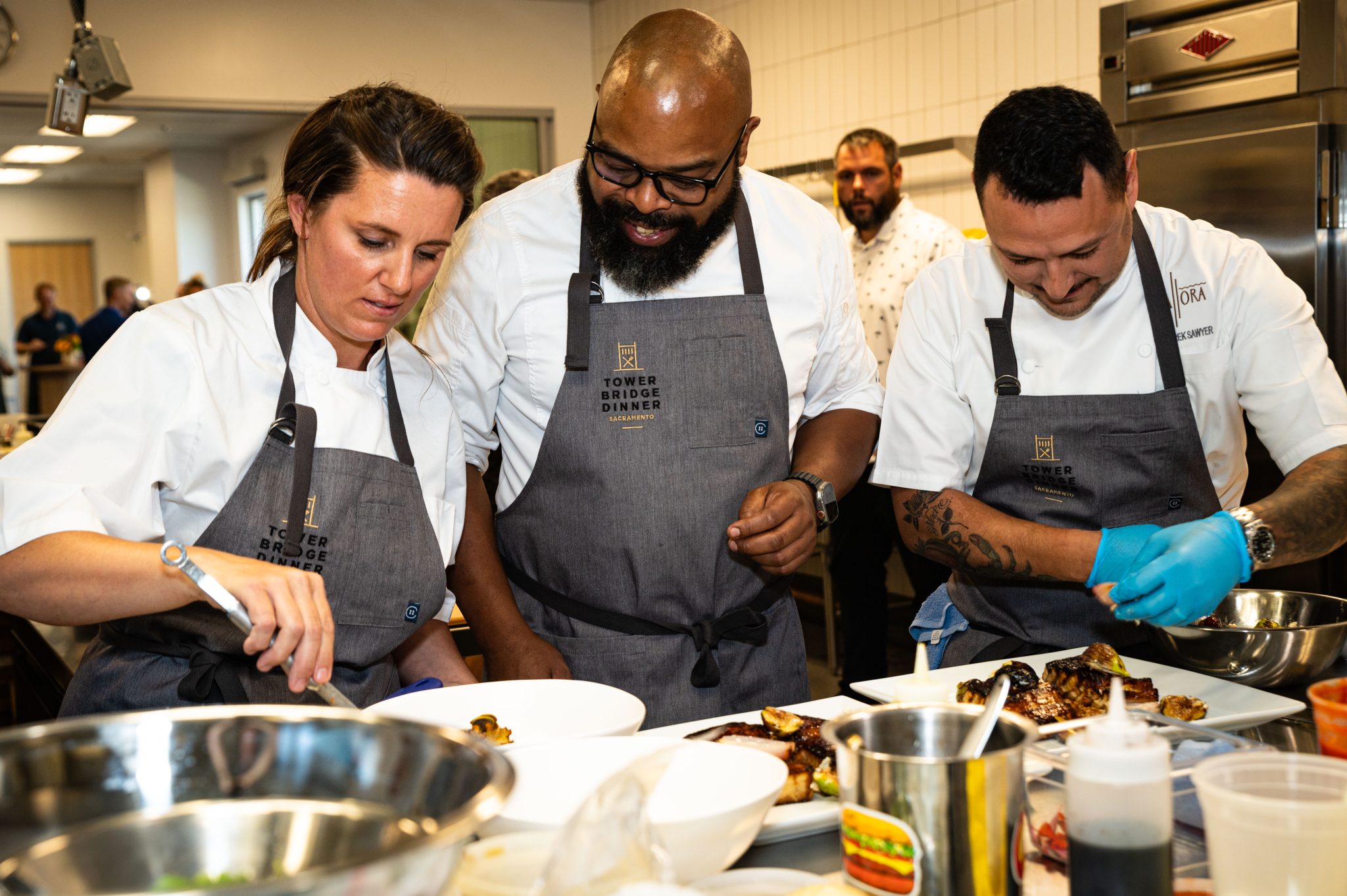 Reb ecca Campbell, Dennis Sydnor, Derek Sawyer, cooking, together, fun, friends, gloves, preparation, Farm to fork festival, sacramento, california, gourmet food, chefs, men and woman, people of color, uniforms, friends, fun, happy, cooks, preview dinner
