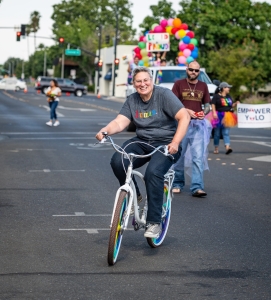human, tshirt, writing, rainbow, bicycler, bike, cute, rainbow tires, reporter, news event, small town, central valley, colorful photos, photography, photographs, Woodland California, Woodland, Yolo County, Pride parade, pride march, downtown, june 2023, chris allan, lgbtq, community, event, photojournalist